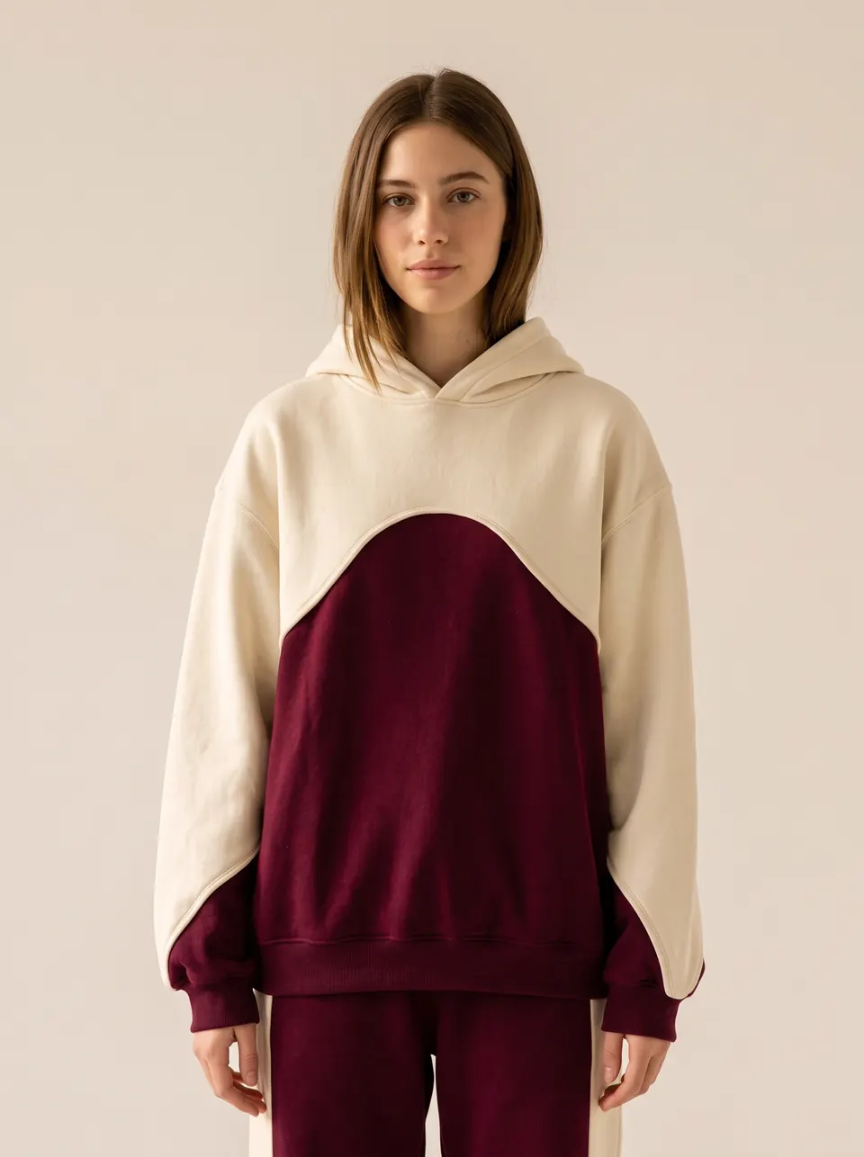 Le hoodie Édition 01, crème et bordeaux, porté de face
