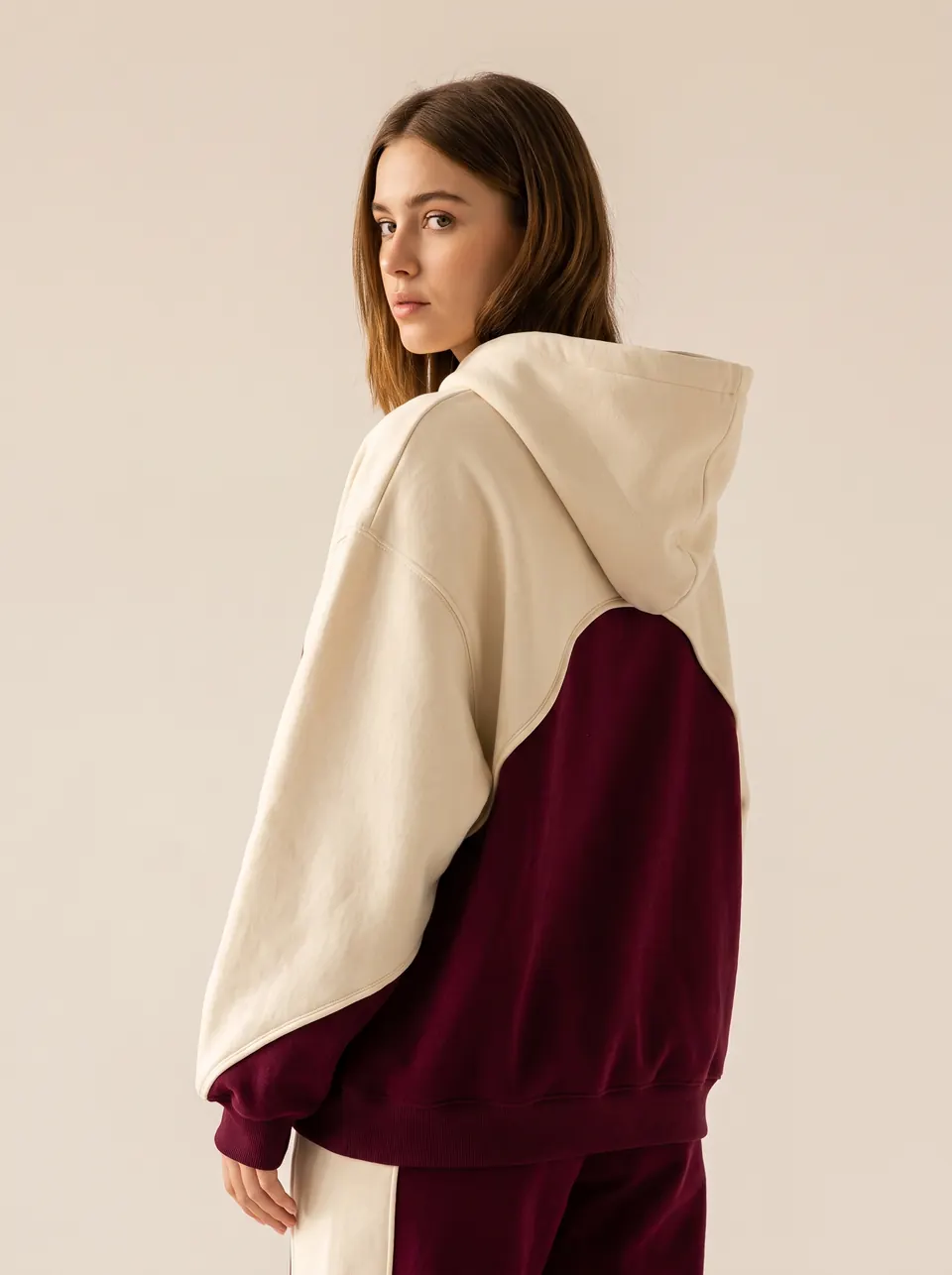 Le hoodie Édition 01 vu de dos, l'arche bordeaux sur le côté