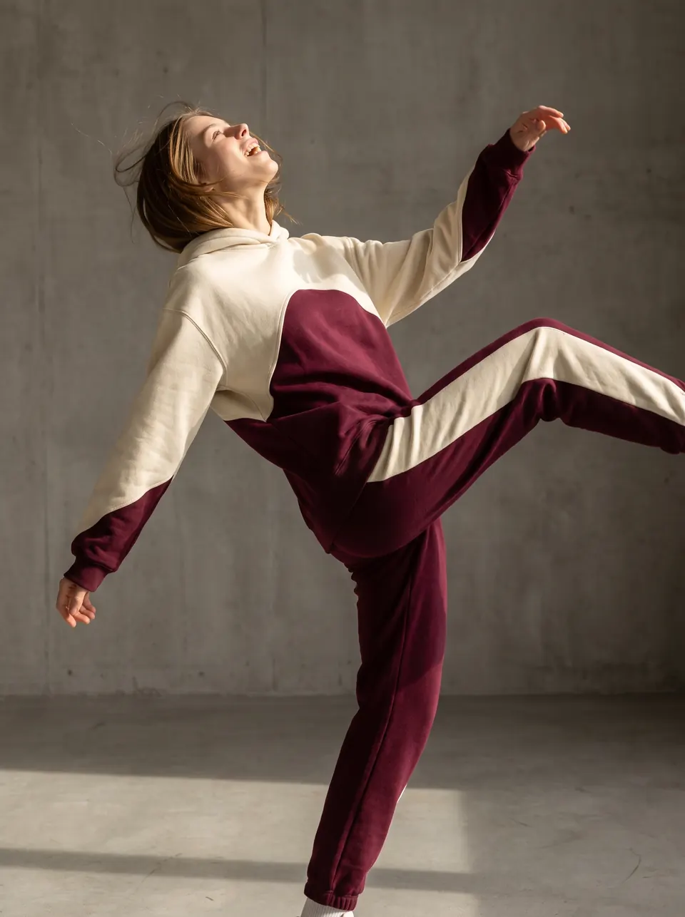 Le hoodie Édition 01 en mouvement, devant un mur de béton